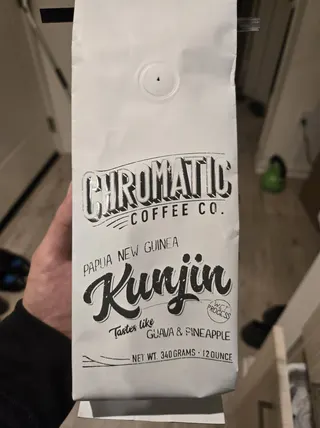 A Chromatic Papua New Guinea Kunjin coffee bag photographed on a kitchen counter.